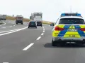 Niemiecki radiowóz na autostradzie, jadący za innymi pojazdami.