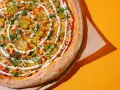 Apetyczna pizza z ogórkiem i sosem, idealna na szybki posiłek. Zastanawiasz się, ile kosztuje pizza we Włoszech?