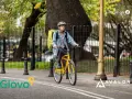 Kurier Glovo na rowerze z żółtą torbą. Dowiedz się, glovo co to jest - szybka dostawa jedzenia i nie tylko!
