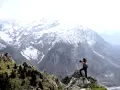 Randonneur contemplant le paysage du Valgaudemar, avec des montagnes enneigées en arrière-plan.
