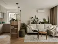 Minimalistyczne wnętrza z dużą ilością zieleni. Jasna kanapa, drewniane meble i kuchnia w neutralnych kolorach tworzą przytulną atmosferę.