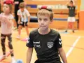 Chłopiec z zabawką na głowie, w koszulce KS Bysstra, podczas zajęć sportowych.