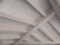 Techo de madera con vigas y tablones, acabado con veladura blanca que resalta la veta natural.
