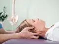 Delikatna terapia krzyżowo czaszkowa dla ulgi w napięciu. Terapeuta delikatnie uciska głowę pacjentki.