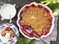 En härlig hallonpaj smulpaj med krispig topping, serverad med vaniljsås. Perfekt sommarfika!