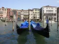Gondole ormeggiate sul Canal Grande, pronte per le escursioni a Venezia. Edifici storici sullo sfondo.