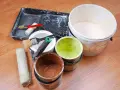 Attrezzi per pittura e barattoli di vernice avanzata, pronti per essere conservati.
