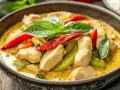 Aromatyczny curry z kurczakiem, z papryczkami chili i bazylią, w misce. Idealne danie, gdy masz ochotę na coś innego niż stir-fry z wołowiną.