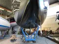 Schwarzer Rumpf einer Yacht im Trockendock, bereit, das Antifouling zu erneuern.