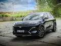 Czarny Geely Starray EM-i gotowy na Road Tour, lśniąc na tle zieleni i chmur.