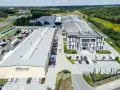 Nowoczesny kompleks produkcyjny Voster producent drzwi, z drogą szybkiego ruchu w tle.