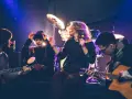 Band bei der Probe, die eine **cover musik** spielt. Sängerin mit Mikrofon, Gitarristen und Schlagzeuger im Scheinwerferlicht.