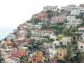 Colorful houses cascade down a hillside towards the sea, a picturesque scene perfect for any Europe itinerary.
