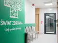 Nowoczesna poczekalnia kliniki medycznej z zieloną ścianą i napisem "Świat Zdrowia".