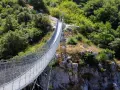 Un lungo ponte tibetano si snoda tra rocce e vegetazione lussureggiante, offrendo un'avventura mozzafiato nei dintorni di Salerno.