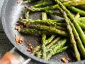 Asparagi in padella, croccanti e saporiti, con pezzetti di pancetta tostata che aggiungono un tocco in più.