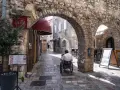 Mężczyzna na wózku inwalidzkim przemierza urokliwe, kamienne uliczki **Budva stare miasto**.