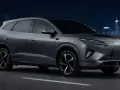 Szary samochód elektryczny BYD na tle nocnego miasta.