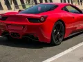 Czerwone Ferrari 458 Italia na torze wyścigowym, widok z tyłu.
