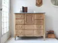 Muebles pintados a la tiza antes y después: cómoda de madera clara con tiradores dorados, lista para un nuevo look.