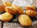Des madeleines dorées, saupoudrées de sucre glace, prêtes à être dégustées. Une invitation à la recette madeleine parfaite.