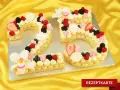 Zahlentorte 25 mit viel Creme, Beeren und Blüten. Ein süßer Genuss für jeden Anlass.