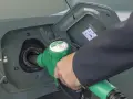 Tankowanie Forda Kuga 2.0 TDCI. Zielony pistolet paliwowy wlewa paliwo do baku.