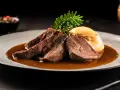 Zartes Tafelspitz-Rezept auf einem Teller mit Sauce, Beilage und Rosmarinzweig.