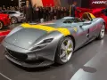 Szary Ferrari Monza SP1 z żółtymi pasami, odsłaniany na scenie.