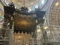 Wnętrze bazyliki z rusztowaniami wokół wspaniałego cyborium. Złoty dysk z gołębicą Ducha Świętego na suficie.