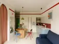Un angolo di casa moderna con richiami alle case tipiche italiane: un tavolo rotondo, sedie colorate e una cucina funzionale.