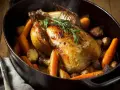 Une pintade en cocotte dorée, garnie de carottes et de pommes de terre rôties, avec des herbes fraîches. Un plat savoureux et réconfortant.
