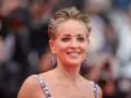 Sharon Stone luce un elegante corte bixie, con pendientes de zafiro y un vestido blanco con detalles azules.