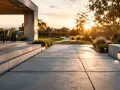 Allée en dalles de béton moderne, avec escalier et jardin paysager au coucher du soleil. Estimation du prix dalle béton 100m2.