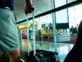 Osoba z walizką czeka na lotnisku. Wymiary bagażu rejestrowanego są kluczowe dla komfortowej podróży.