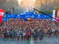 Multitudinaria salida del maratón Sevilla 2026, con miles de corredores bajo el arco de meta.