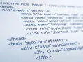 Fragment kodu HTML, pokazujący podstawy tworzenia strony internetowej: doctype, head z tytułem i meta tagami, oraz body z atrybutami i divami.