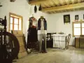 Tradycyjne stroje ludowe, kołowrotek i obrazy religijne tworzą klimat dawnej wsi. To żywa hel historia.
