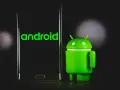 Zielony robot Android obok telefonu z logo Android 13.
