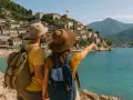 Para zwiedza malownicze miasteczko na wzgórzu w **Ekuz Albania**, z widokiem na turkusowe morze.