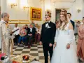 Uroczystość zaślubin w cerkwi. Pan młody, niczym ludowy grajek z Ukrainy, w eleganckim czarnym garniturze, z narzeczoną w białej sukni, przyjmują błogosławieństwo.