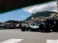 Coche de clasificación F1 en Mónaco, con el mar y edificios de lujo de fondo.
