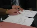 Dwóch mężczyzn analizuje dokumenty. Jeden z nich, w garniturze i z pierścieniem na palcu, wskazuje na tabelę. Pytanie: Millennium Bank zajęcie egzekucyjne jak sprawdzić?