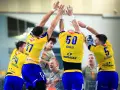 Piłkarze ręczni w żółtych koszulkach, prawdopodobnie z drużyny Kielc, świętują zwycięstwo nad Aalborgiem.