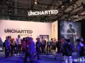 Gente en un evento de videojuegos, con carteles de Uncharted 4 y The Nathan Drake Collection. Se ven varios capítulos de Uncharted.