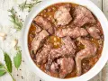 Coniglio in padella, un piatto succulento con olive e aromi, pronto per essere gustato.
