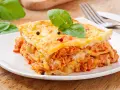 Pyszna lasagne z mięsem i serem, ozdobiona bazylią i pieprzem. Idealna na obiad, czy to lasagne czy cannelloni, smakuje wybornie.