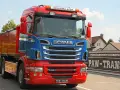 Czerwono-niebieska wywrotka do zboża Scania R560 z napisem "Królowa Szos" gotowa do pracy.