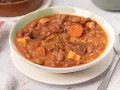 Un tazón de judías pintas con chorizo, patatas y arroz en un guiso meloso.