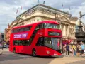 Czerwony piętrowy autobus w Londynie na tle Piccadilly Circus.